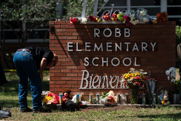 A law enforcement personnel lights a candle outside Robb Elementary School in Uvalde, Texas, on Wednesday. Uvalde has a large Mexican American population.