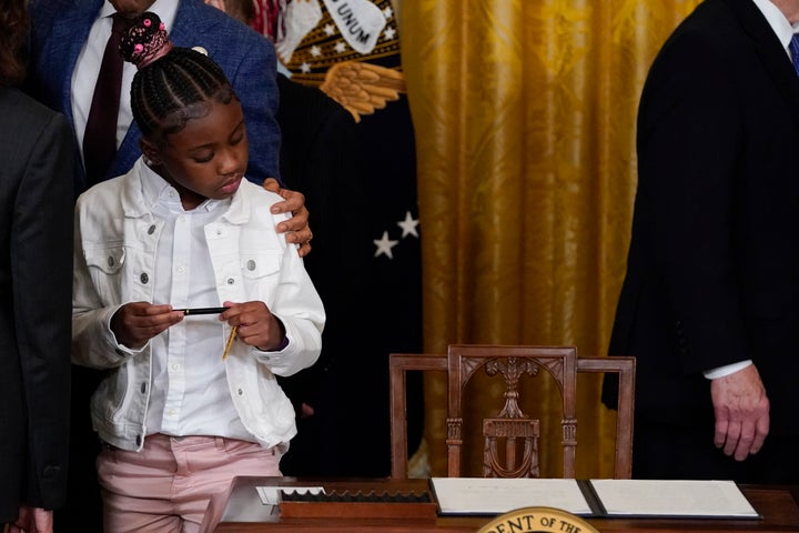 Gianna Floyd, hija de George Floyd, mira la orden ejecutiva que Joe Biden acababa de firmar, en la Casa Blanca.