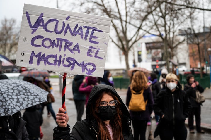 MADRID, SPAIN - 2021/03/08: A woman carrying a placard reading 'Get vaccinated against machismo' protesting during International Women's Day in the neighborhood of Vallecas. Despite the prohibitions to carry out demonstrations in Madrid according to health reasons due to the coronavirus (COVID-19) pandemic, women have taken to the streets on different neighborhoods to celebrate International Women's Day. (Photo by Marcos del Mazo/LightRocket via Getty Images)