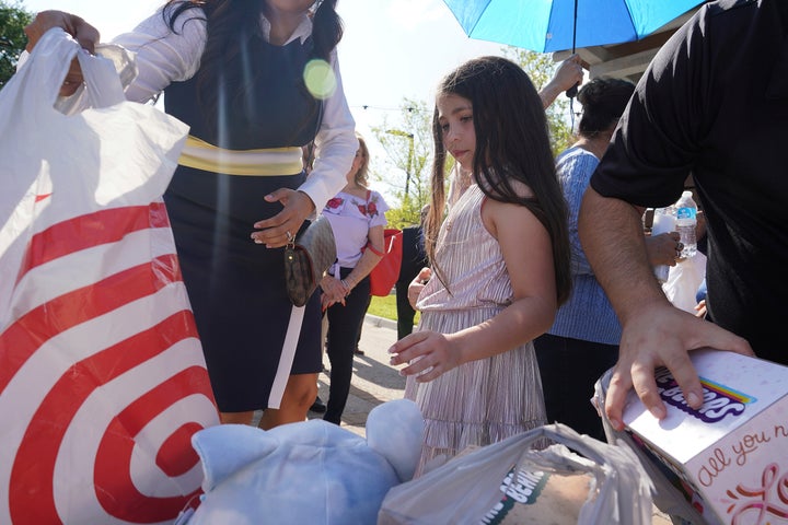 Madeleine Rigney, 9, places a stuffed bear to be donated to the shooting victims at Robb Elementary School in Uvalde, Texas, during a community prayer Wednesday, May 25, 2022, in Pharr, Texas. (Joel Martinez/The Monitor via AP)