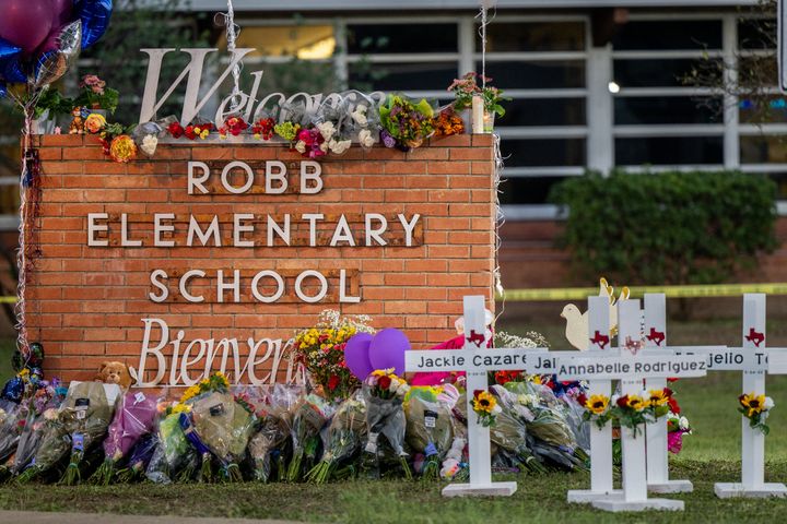 A memorial is seen Thursday surrounding the Robb Elementary School sign following Tuesday's mass shooting in Uvalde, Texas.