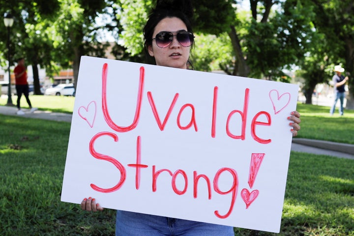 Raven Vazquez holds a sign at the town square in Uvalde, Texas, on Wednesday.