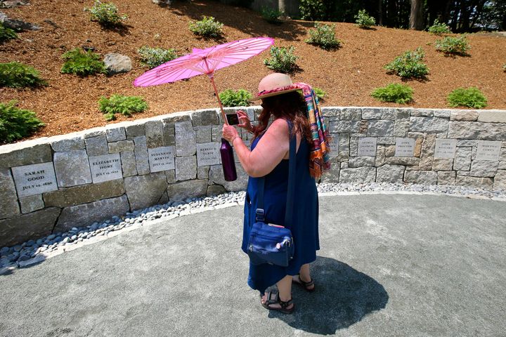 Karla Hailer, a fifth-grade teacher from Scituate, Mass., takes a video on July 19, 2017, where a memorial stands at the site in Salem, Mass., where five women were hanged as witches more than three centuries years earlier. 