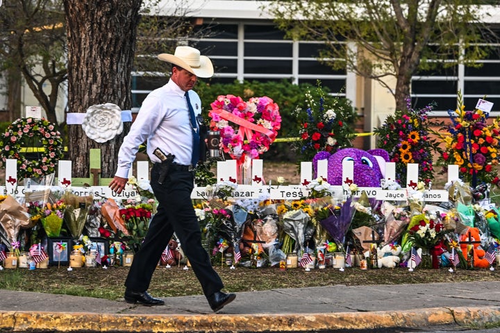 Oficial policial frente al memorial en Uvalde, Texas.