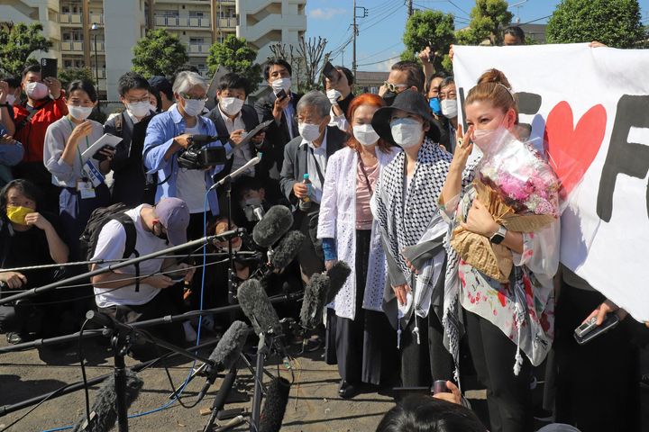 Η Φουσάκο Σιγκενόμπου, με το μαύρο καπέλο στην μέση και η κόρη της Μέι, στα δεξιά, μιλά σε δημοσιογράφους κατά την έξοδο της από τις φυλακές της Ακισίμα.