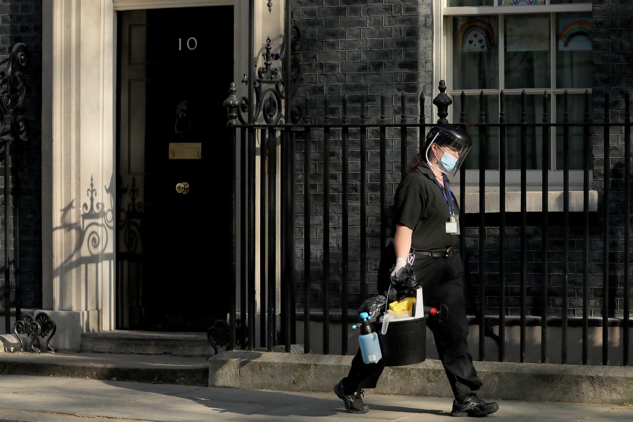 A cleaner wearing face mask leaves 10 Downing Street on April 16, 2020. 