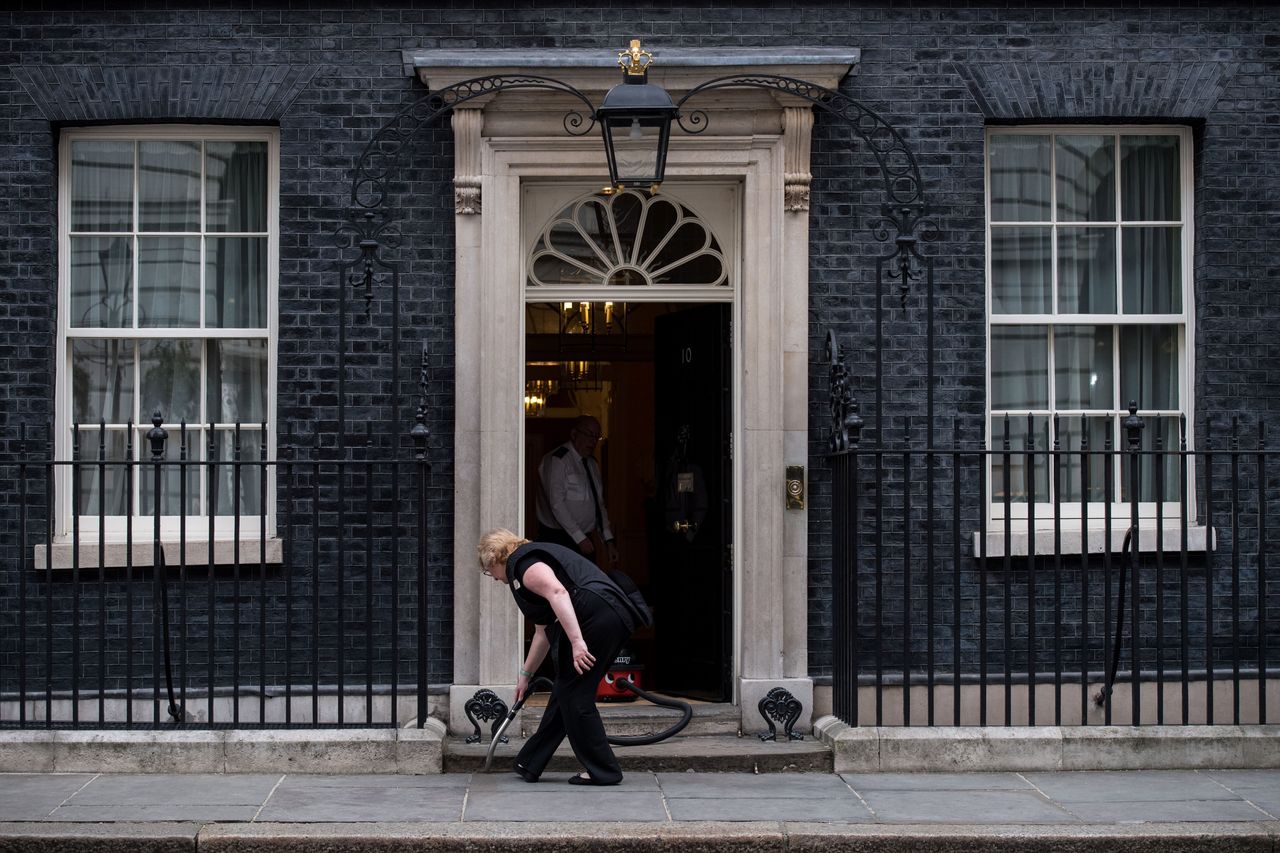 A worker vacuum cleans the doorstep of 10 Downing Street in London.