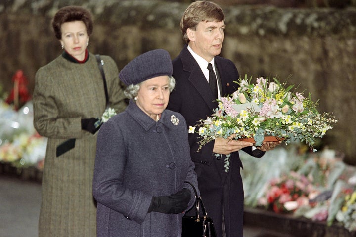 British Queen Elizabeth II (C) arrives on March 17, 1996 with Princess Ann and a member of the Scottish Office to lay a wreath et the entrance of Dunblane Primary School, where a gunman shot 16 children and a teacher on March 13, 1996. / AFP / GERRY PENNY