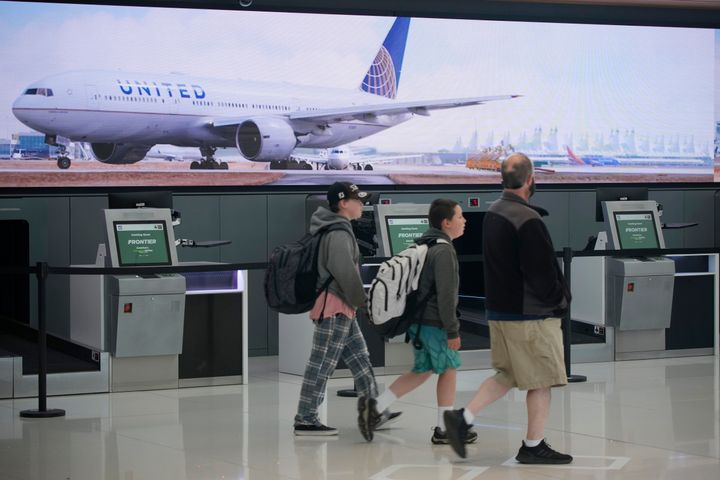Travelers walk past a United Airlines ticketing counter at Denver International Airport in Denver, Colorado on Thursday.