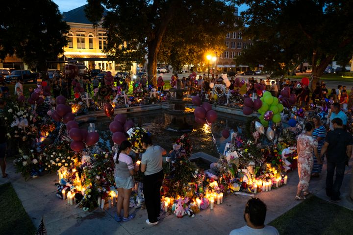People visit a memorial set up in a town square to honor the victims killed in the elementary school shooting earlier in the week in Uvalde, Texas, late Saturday, May 28, 2022. (AP Photo/Jae C. Hong)