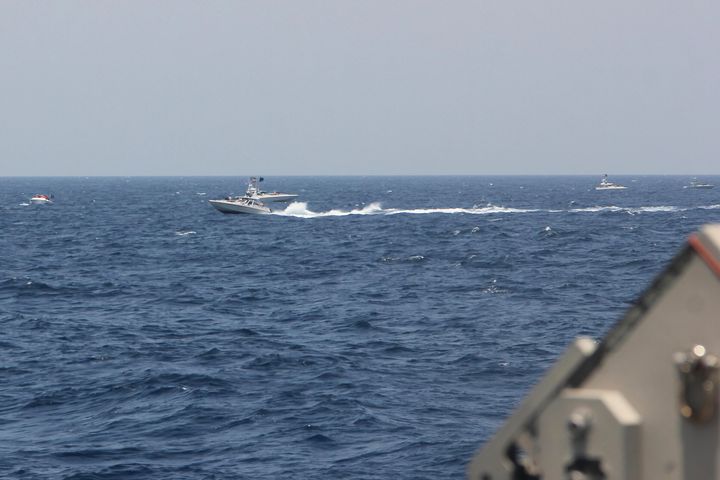 In this image provided by the U.S. Navy, an Iranian Islamic Revolutionary Guard Corps Navy (IRGCN) fast in-shore attack craft (FIAC), a type of speedboat armed with machine guns, speeds near U.S. naval vessels transiting the Strait of Hormuz, Monday, May 10, 2021. U.S. officials say a group of 13 armed speedboats of Iran’s Revolutionary Guard made “unsafe and unprofessional” high-speed maneuvers toward U.S. Navy vessels in the Strait of Hormuz on Monday. A U.S. Coast Guard cutter fired warning shots when two of the Iranian boats came dangerously close. (U.S. Navy via AP)