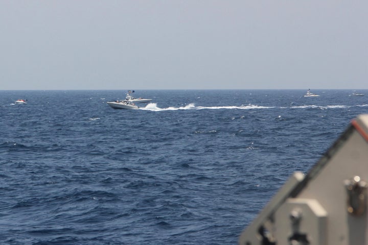 In this image provided by the U.S. Navy, an Iranian Islamic Revolutionary Guard Corps Navy (IRGCN) fast in-shore attack craft (FIAC), a type of speedboat armed with machine guns, speeds near U.S. naval vessels transiting the Strait of Hormuz, Monday, May 10, 2021. U.S. officials say a group of 13 armed speedboats of Iran’s Revolutionary Guard made “unsafe and unprofessional” high-speed maneuvers toward U.S. Navy vessels in the Strait of Hormuz on Monday. A U.S. Coast Guard cutter fired warning shots when two of the Iranian boats came dangerously close. (U.S. Navy via AP)