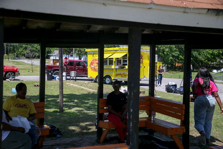 Witnesses gather under a gazebo a the scene of a fatal shooting that happened at a Memorial Day event in Taft, Okla., on May 29, 2022. 