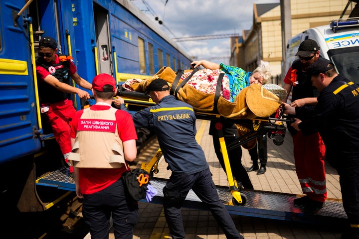 A patient is carried on a stretcher to board a medical evacuation train run by MSF (Doctors Without Borders) at the train station in Pokrovsk, eastern Ukraine, Sunday, May 29, 2022. The train is specially equipped and staffed with medical personnel, and ferries patients from overwhelmed hospitals near the front line, to medical facilities in western Ukraine, far from the fighting.