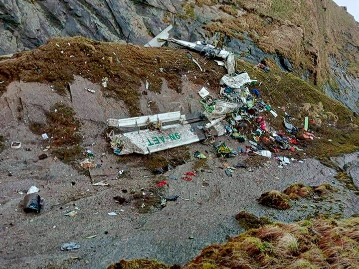 This handout photograph released by Fishtail Air shows the wreckage of a plane in a gorge in Sanosware in Mustang district close to the mountain town of Jomsom, west of Kathmandu, Nepal, on May 30, 2022. 