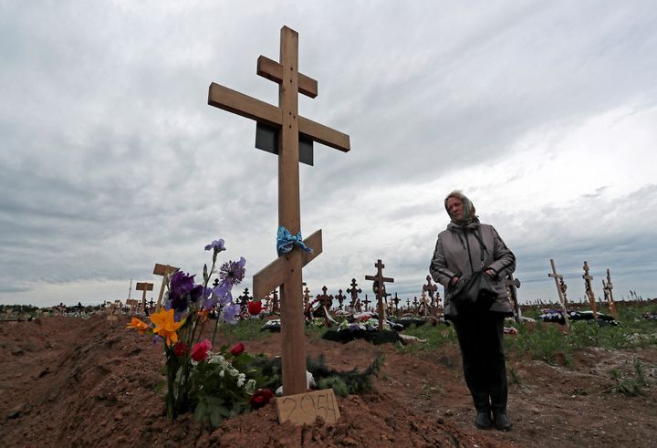 Η Ναταλία, 57 ετών, στέκεται δίπλα στον τάφο του γιου της σε ένα νεκροταφείο κατά τη διάρκεια της σύγκρουσης Ουκρανίας-Ρωσίας στον οικισμό Staryi Krym έξω από τη Μαριούπολη, Ουκρανία, 22 Μαΐου 2022. REUTERS/Alexander Ermochenko
