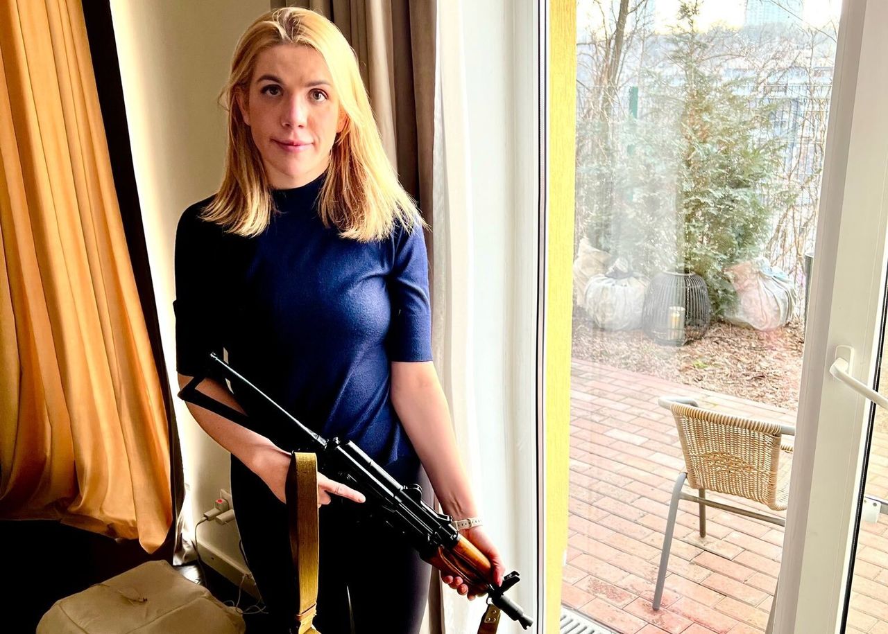 Kira Rudik holding a Kalashnikov rifle