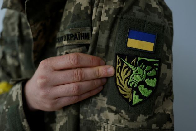 Antonina Romanova, de 37 años, miembro de la Defensa Territorial, muestra la insignia de unicornio en su uniforme que simboliza a la comunidad LGTBI+, el día de su partida al frente en su casa en Kiev, el 25 de mayo de 2022.
