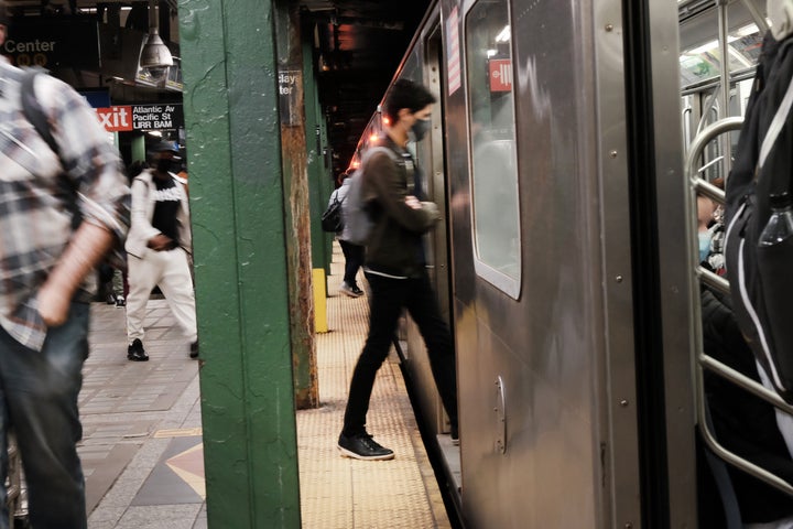 People enter a train at a Brooklyn subway station a day after a man shot numerous people on a Manhattan bound train in the Sunset Park neighborhood of Brooklyn on April 13, 2022.