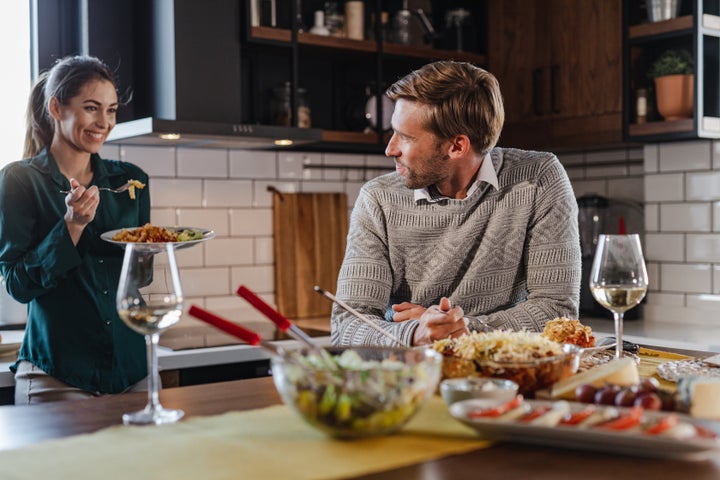 A young man and woman eating homemade meal at home