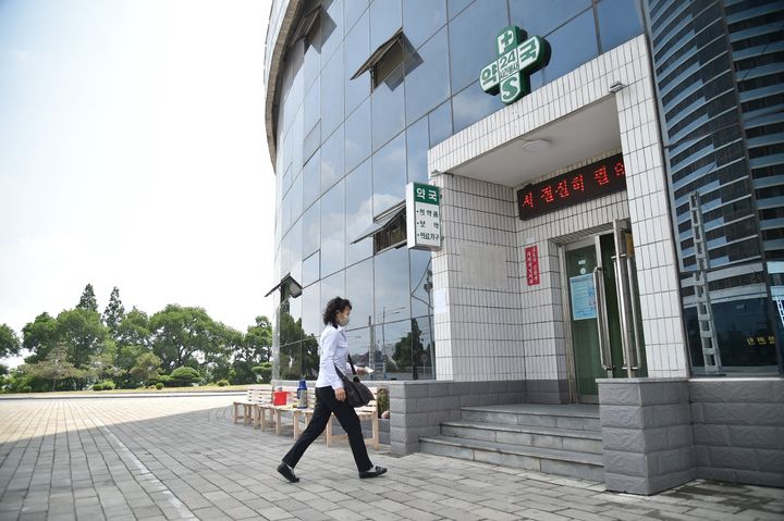 A woman walks into a pharmacy to purchase medicine in Pyongyang on May 27, 2022. - Health care workers in North Korea are "intensifying" Covid tests and treatments across the country, state media said on May 27, days after the impoverished country reaffirmed the epidemic was now "clearly" under control. (Photo by KIM Won Jin / AFP) (Photo by KIM WON JIN/AFP via Getty Images)