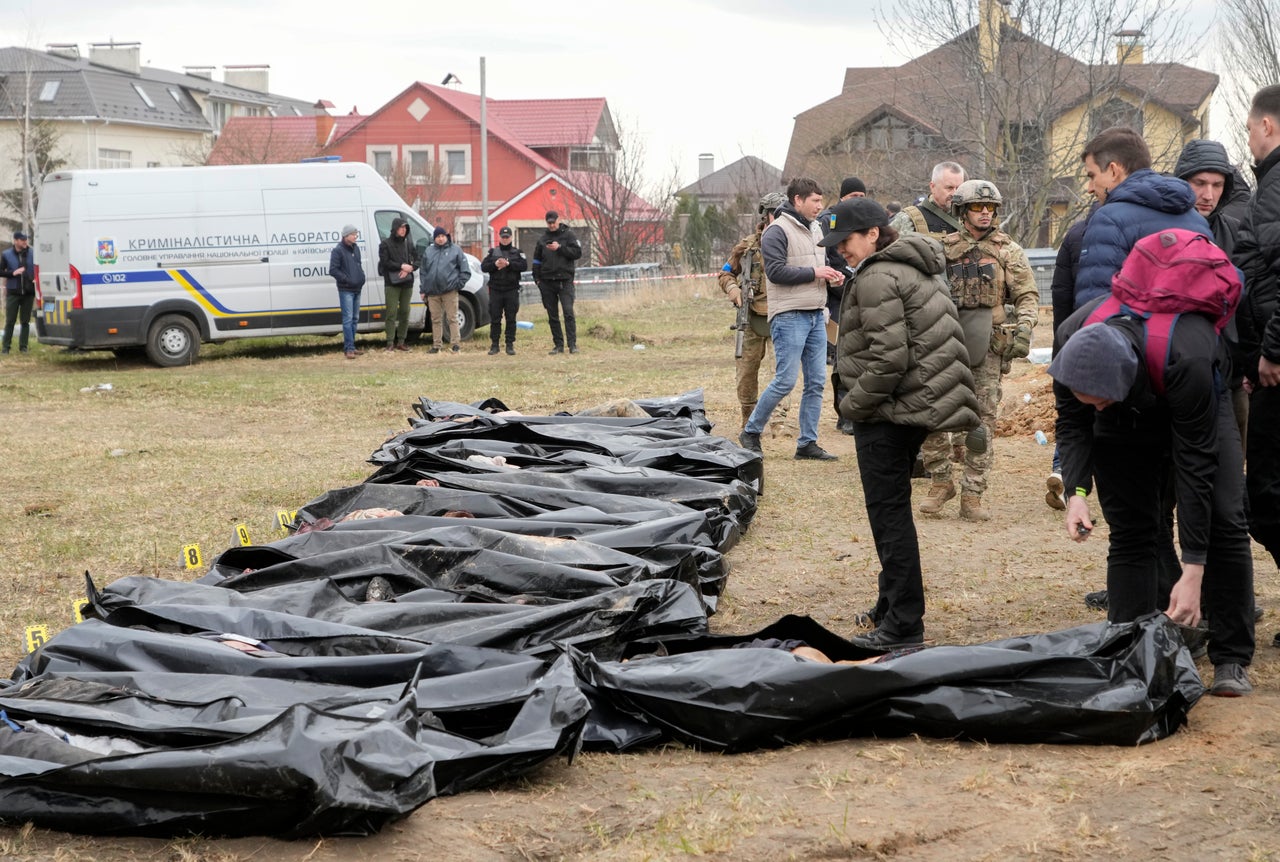 Ukrainian Prosecutor General Iryna Venediktova, center, looks at the exhumed bodies of civilians killed during the Russian occupation in Bucha.
