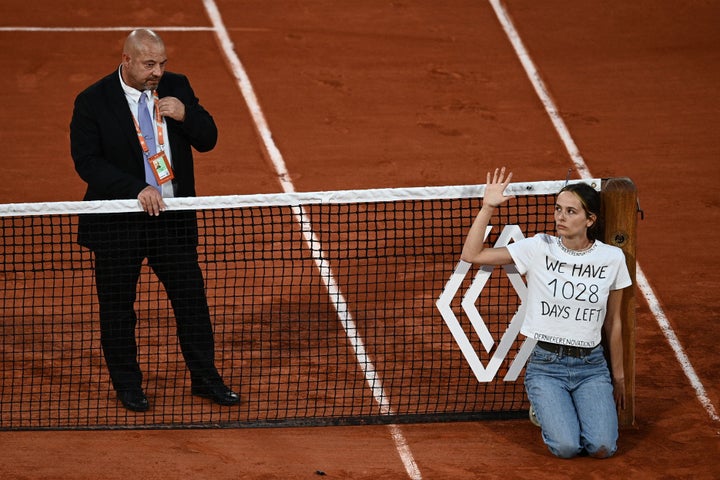 Una manifestante encadenada en la red de Roland Garros.