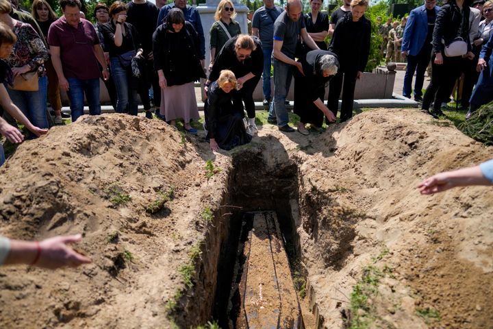 Relatives of Army Col. Oleksander Makhachek mourn during his funeral in Zhytomyr, Ukraine, Friday, June 3, 2022. 