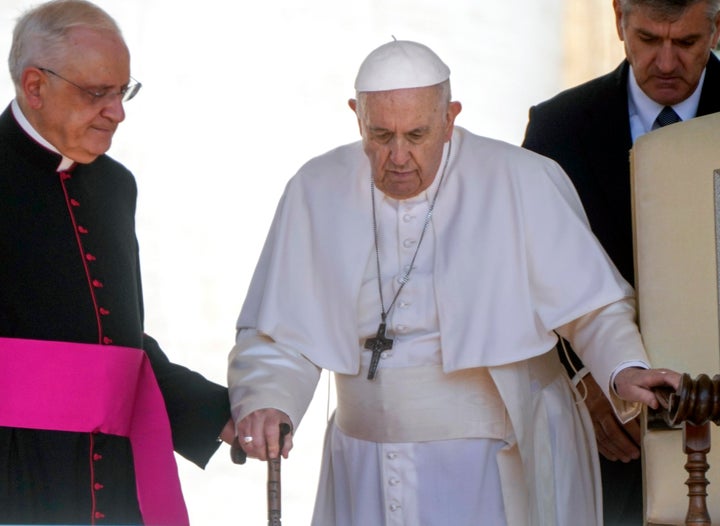 Pope Francis is helped by his aide Monsignor Leonardo Sapienza, left, as he walks with a cane to his weekly general audience in St. Peter's Square at The Vatican on June 1, 2022. Pope Francis added fuel to rumors about the future of his pontificate on Saturday by announcing he would visit the central Italian city of L'Aquila in August for a feast initiated by Pope Celestine V, one of the few pontiffs who resigned before Pope Benedict XVI stepped down in 2013. (AP Photo/Gregorio Borgia, File)