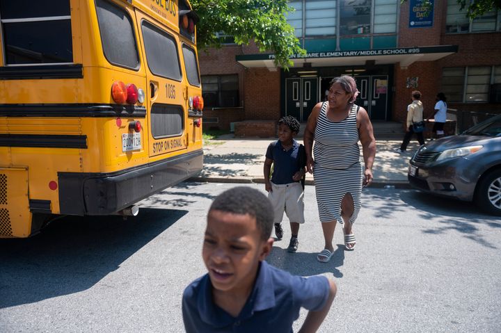 Latoya Carroll, picks up her children, Xavier Braxton, 8, and Jayden Braxton, 7, during the early dismissal at Franklin Square Elementary/Middle School due to lack of air conditioning in the school building and high temperatures, on May 31, 2022, in Baltimore.