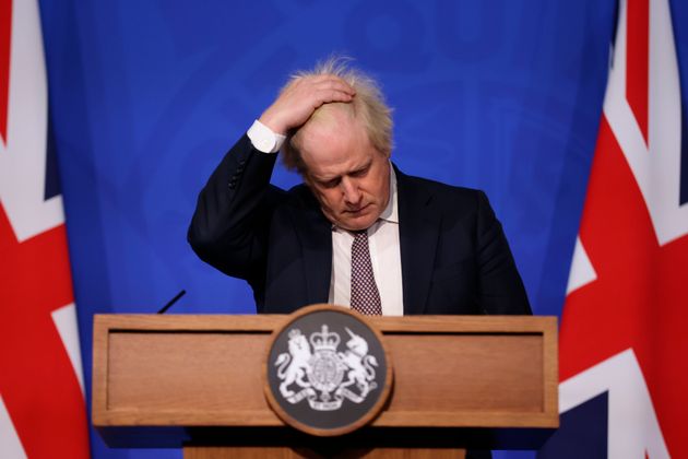 Boris Johnson, ici lors d'une conference de presse sur le Covid en novembre 2021 fait face à...