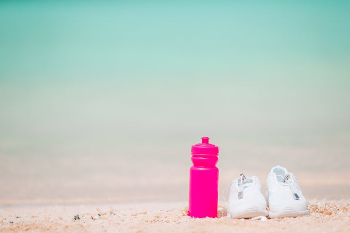 Sport white shoes on tropical sandy beach