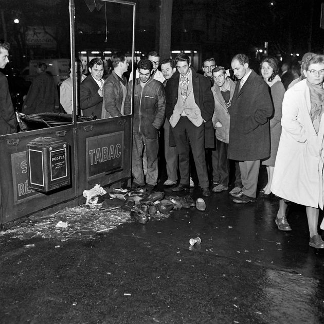 Des passants regardent les chaussures d'Algériens victimes de la répression le 17 octobre 1961 à Paris.