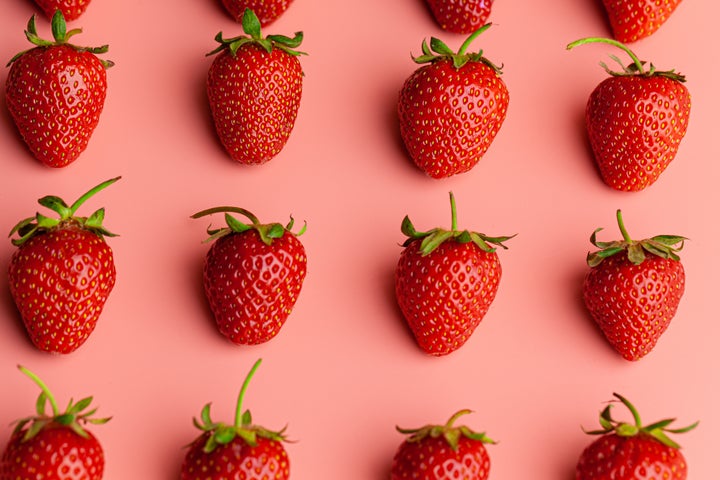 Strawberry on pink background. Creative food concept. Close up.