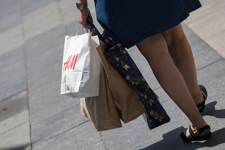 Una mujer con varias bolsas de distintas tiendas de moda.