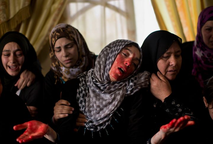 Una mujer llora, manchada por la sangre de su hermano muerto por tropas israelíes, en Hebrón, Cisjordania, en 2013. 