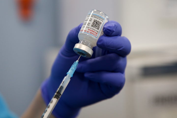 A health worker draws the Moderna COVID-19 vaccine at a vaccination clinic. Moderna has been testing an experimental vaccine that combines Moderna's original shot with protection against the omicron variant.