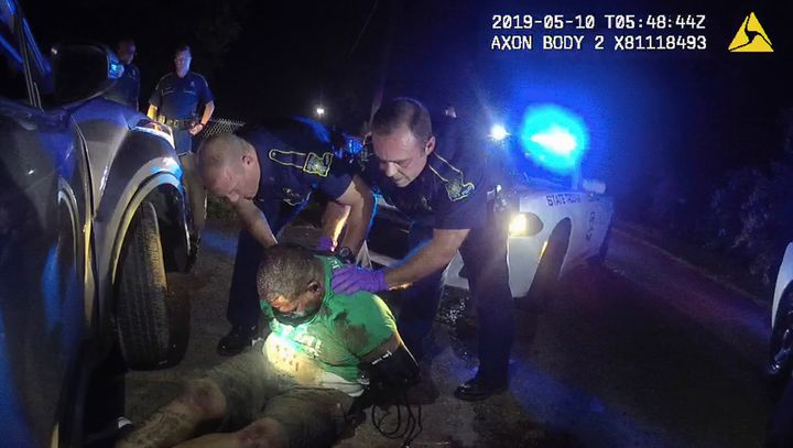 In this image from the body camera of Louisiana State Police Trooper Dakota DeMoss, his colleagues, Kory York, center left, and Chris Hollingsworth, center right, hold up Ronald Greene before paramedics arrived on May 10, 2019, outside of Monroe, La. (Louisiana State Police via AP, File, File)