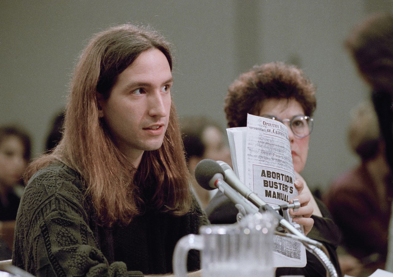 David Gunn Jr., of Birmingham, Alabama, whose father was killed outside a Florida abortion clinic, holds up an "Abortion Buster's Manual" while testifying before a House Judiciary subcommittee in 1993.