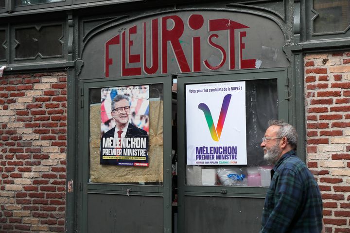 Ένας άνδρας περνάει δίπλα από προεκλογικές αφίσες που γράφει "Melenchon Prime Minister" για τη συμμαχία των αριστερών κομμάτων που έχει συνενωθεί από τον ηγέτη της σκληρής αριστεράς Jean-Luc Melenchon, Παρασκευή 10 Ιουνίου 2022 στη Λιλ, στη βόρεια Γαλλία