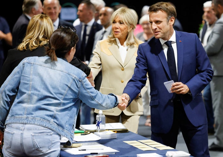 French President Emmanuel Macron and French first lady Brigitte Macron attend to vote in the first round of French parliamentary elections, at a polling station in Le Touquet, France, June 12, 2022. Ludovic Marin/Pool via REUTERS