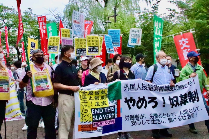 制度廃止を求めるデモ行進に参加する技能実習生や支援者ら=東京都内、6月12日