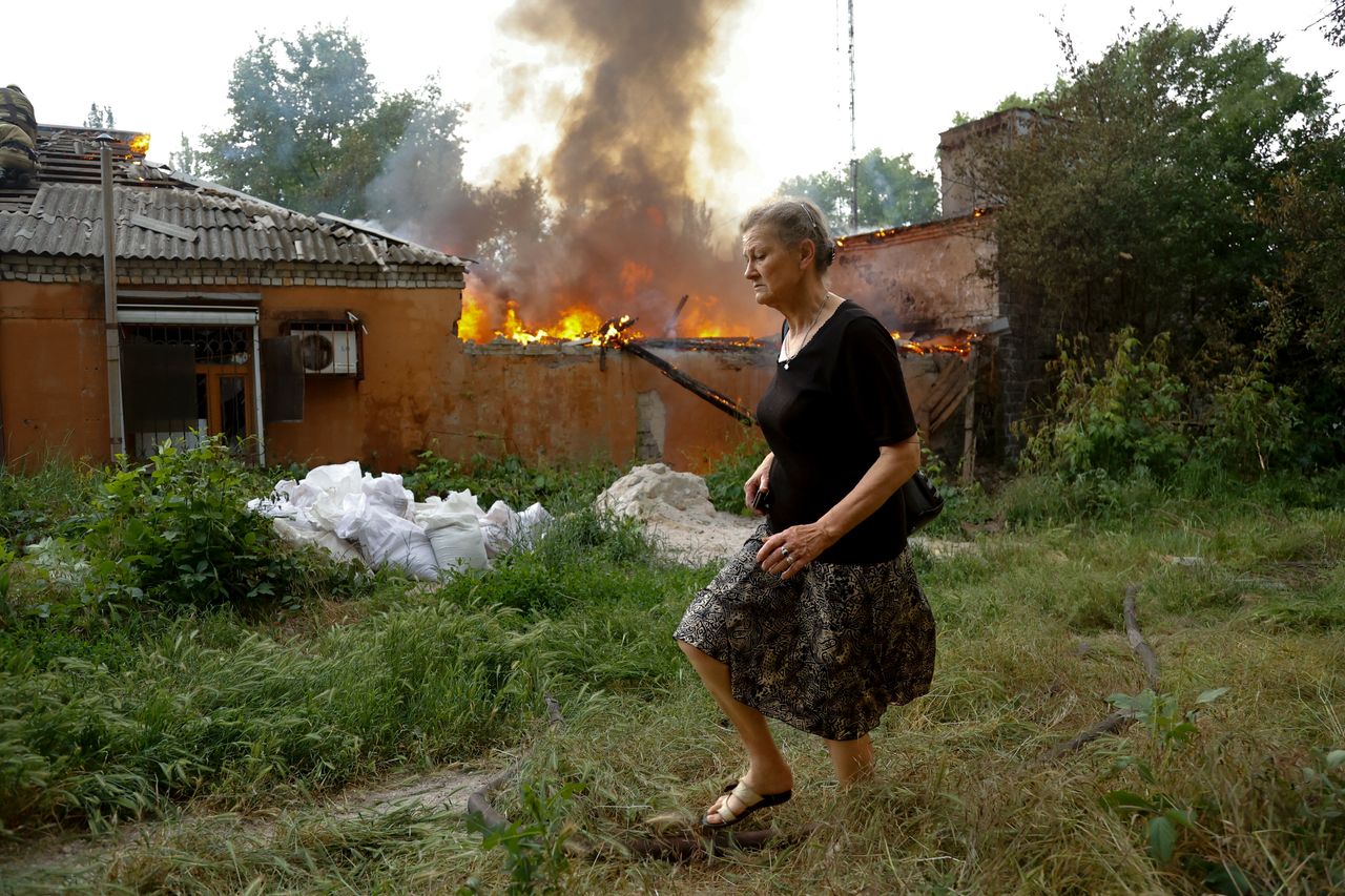 A woman runs from a house that's on fire after shelling in Donetsk earlier this month. 