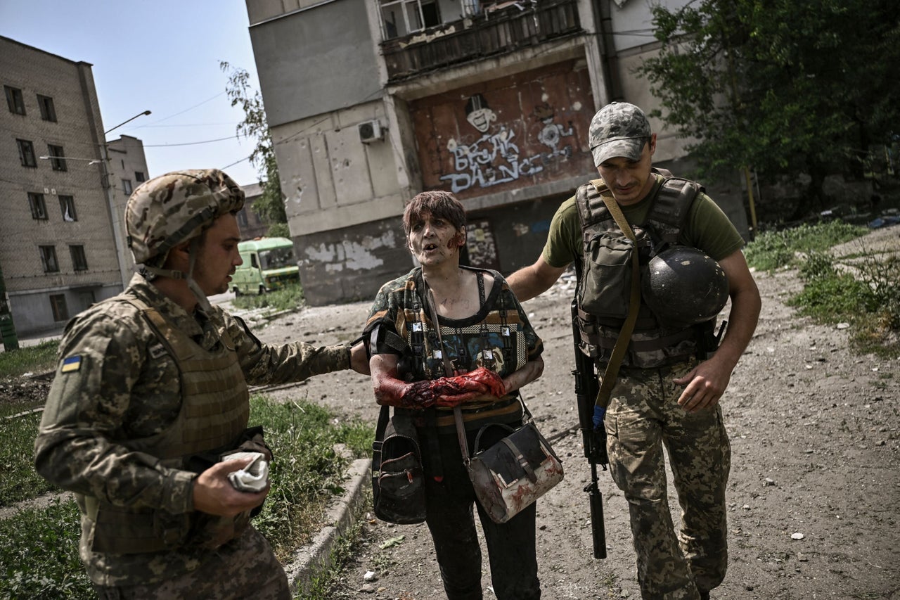 A wounded woman is treated by Ukrainian servicemen during an artillery duel between Ukrainian and Russian troops in the city of Lysychansk on June 11.