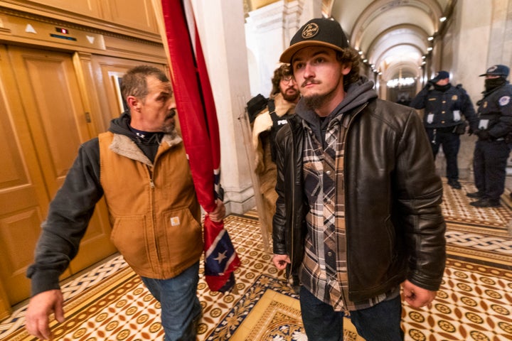 Insurrectionists loyal to President Donald Trump, including Kevin Seefried, left, walk on a hallway after a confrontation with Capitol Police officers outside the Senate Chamber inside the Capitol, on Jan. 6, 2021 in Washington.