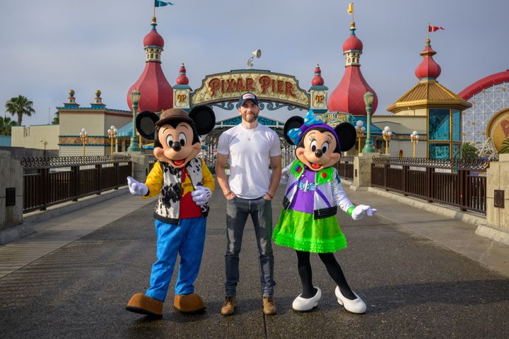 A very serious Chris Evans poses with Mickey and Minnie Mouse on Saturday.