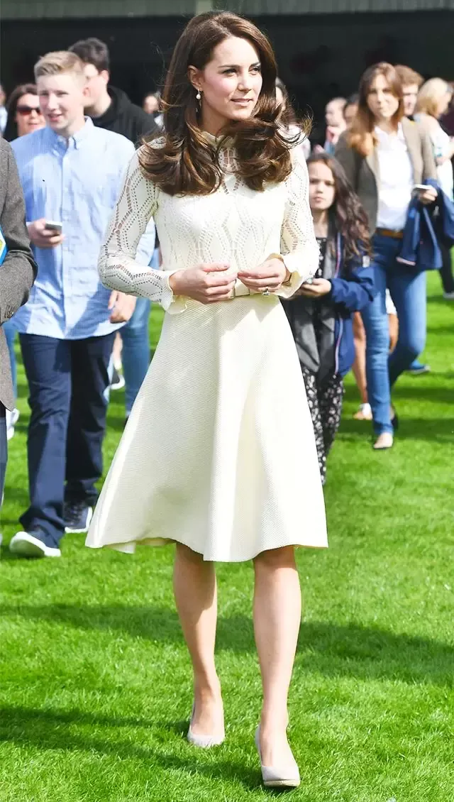 Η Δούκισσα του Κέιμπριτζ, Κέιτ Μίντλετον, με λευκό μίντι φόρεμα με πλεκτές λεπτομέρειες στο μανίκι, συνδυασμένο με γόβες σε γήινη απόχρωση.