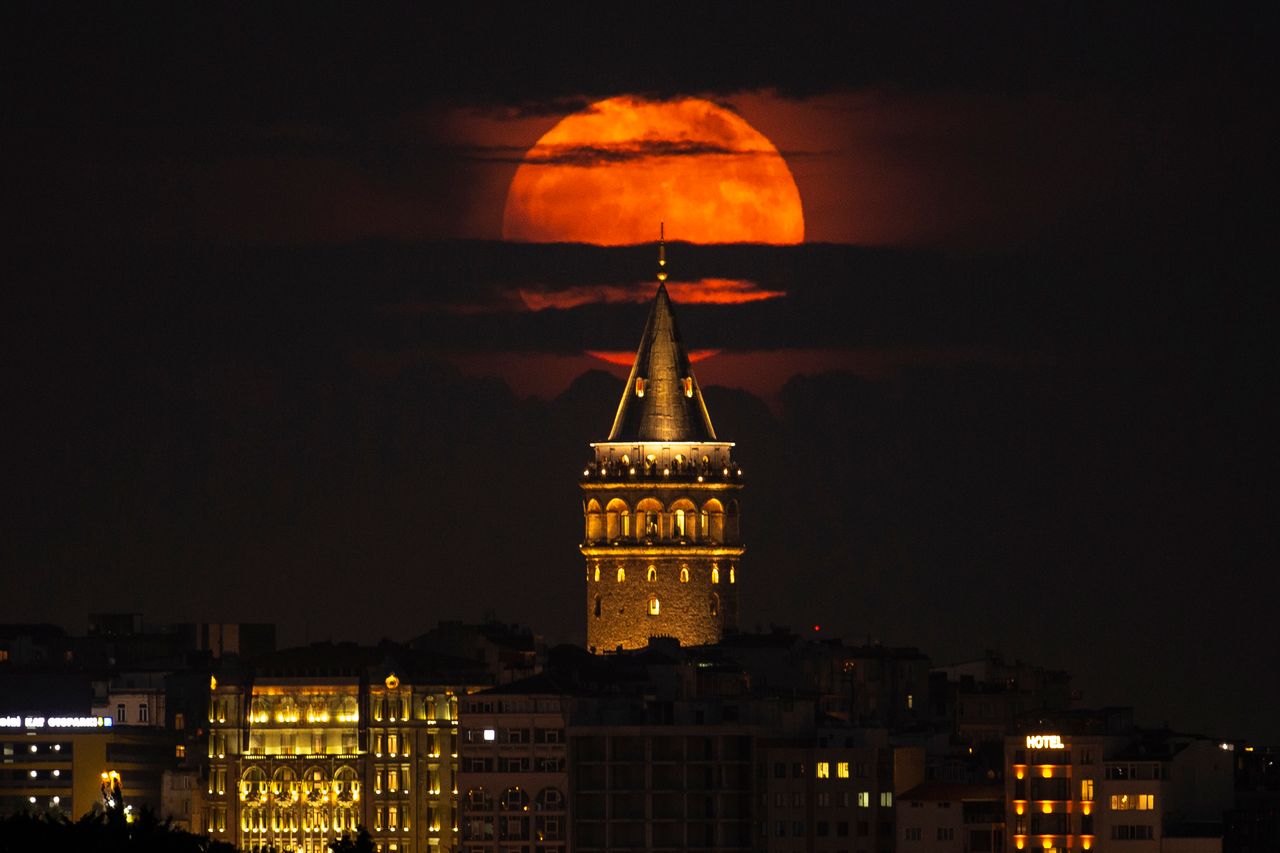 To φεγγάρι ανατέλλει πίσω από τον Πύργο του Γαλατά στην Κωνσταντινούπολη, Τουρκία, Τρίτη, 14 Ιουνίου 2022.