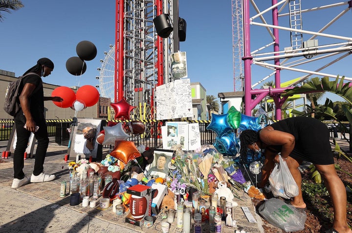 Family and friends of Tyre Sampson leave flowers and other items at a vigil in front of the Orlando FreeFall drop tower in Florida on March 28.