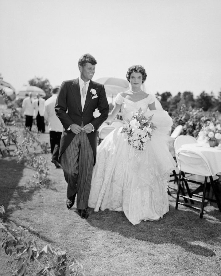 H Τζάκι Κένεντι, εκθαμβωτική με λευκό έξωμο νυφικό, με γεμάτη φούστα και λευκό μαργαριταρένιο κολιέ να διακοσμεί το λαιμό της, στο γάμο της με τον Τζον Κένεντι, το 1953.